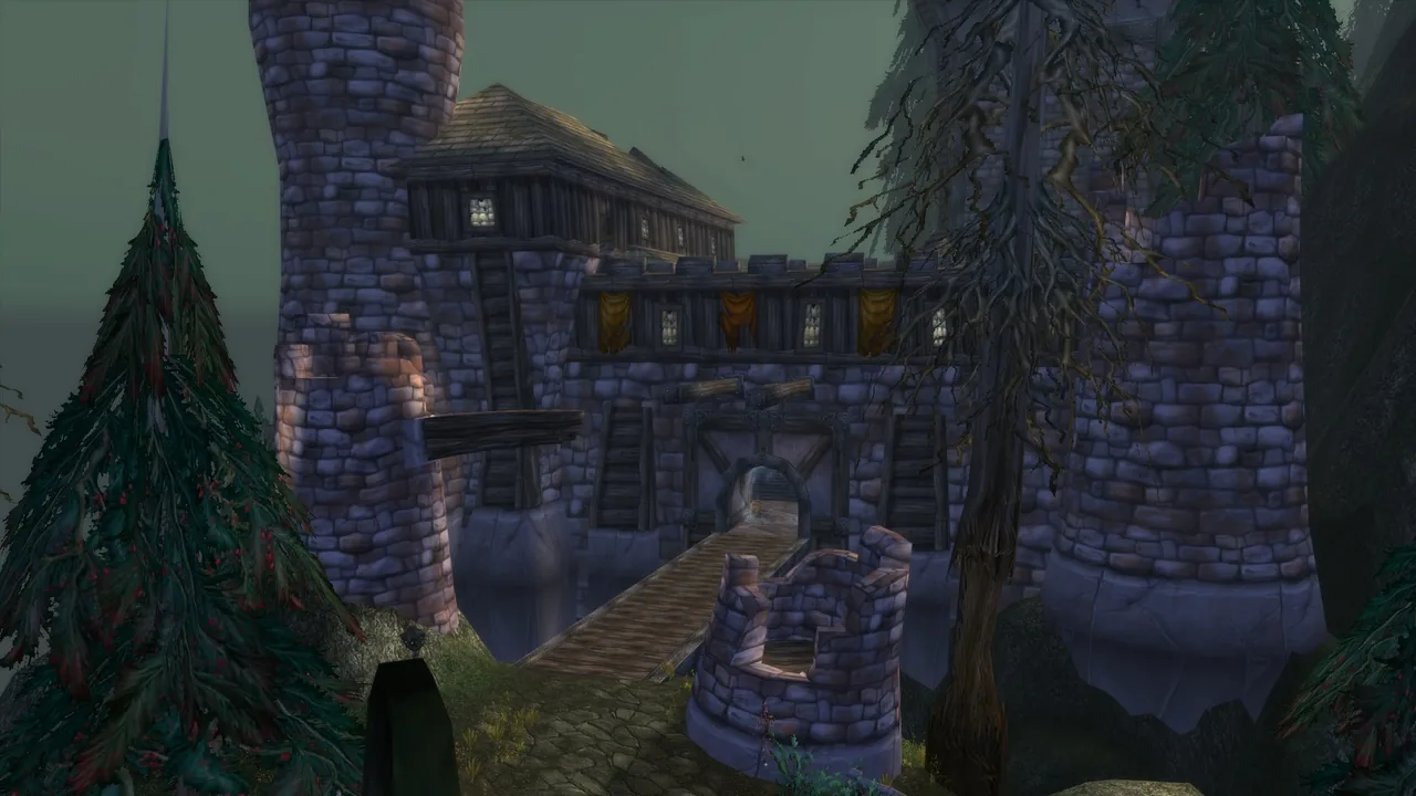 Shadowfang Keep's stone towers and central gate, with a narrow bridge leading toward the entrance above the forest