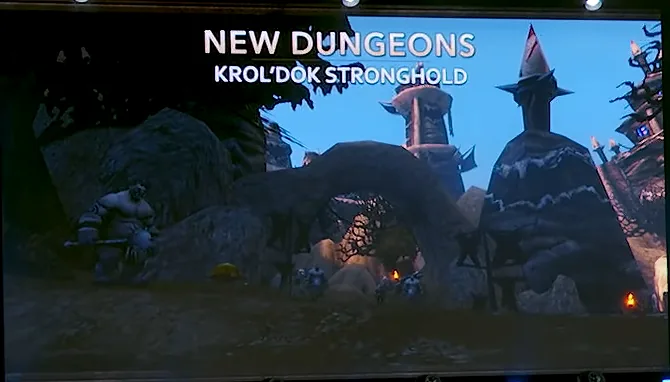 Bühnenbildschirm der BlizzCon 2026 mit dem Titel New Dungeons, Krol'dok Stronghold, der einen Oger neben Türmen aus spitzen Felsen und einem Steinbogen zeigt