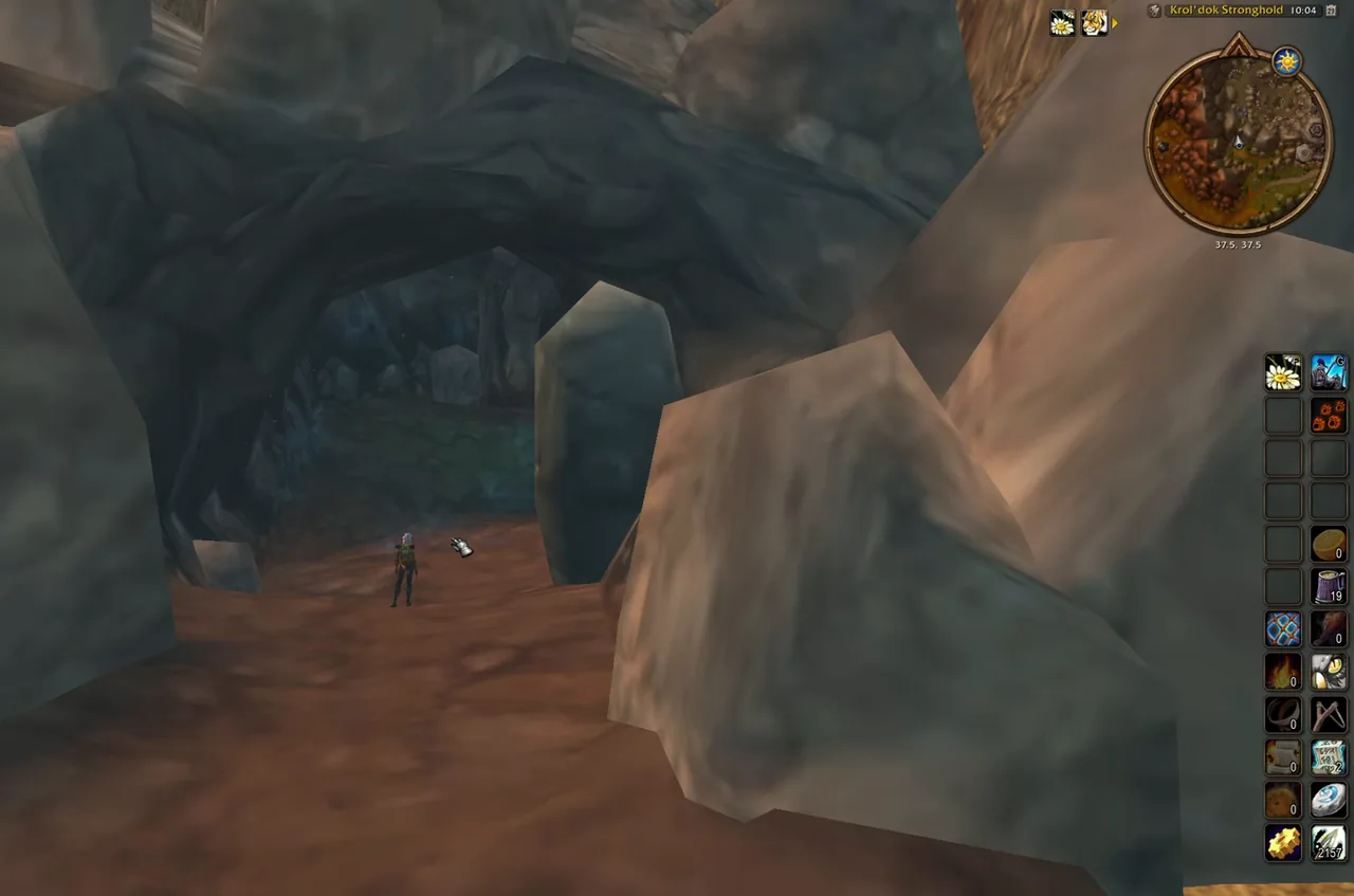 Höhleneingang zwischen grauen Felsbrocken in Flusslande, mit dem Zonenschild „Feste Krol'dok“ und der Minimap bei 37,5, 37,5