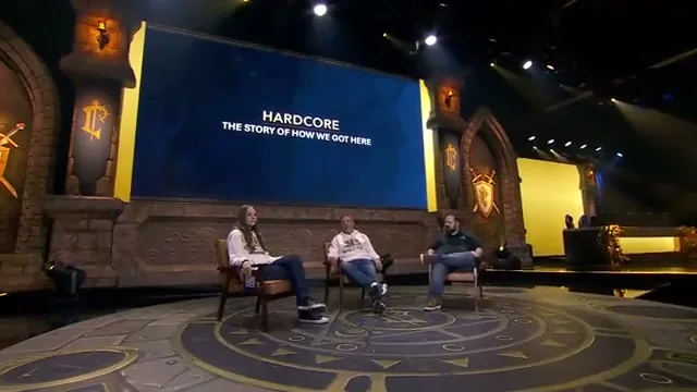 BlizzCon stage with three panelists seated in front of a screen reading HARDCORE, THE STORY OF HOW WE GOT HERE